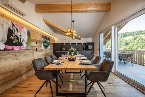 Der großzügige Essbereich bietet Platz für Freunde und Familie Moderne Esszimmer mit Holztisch, eleganten Stühlen und Blick auf die Landschaft.